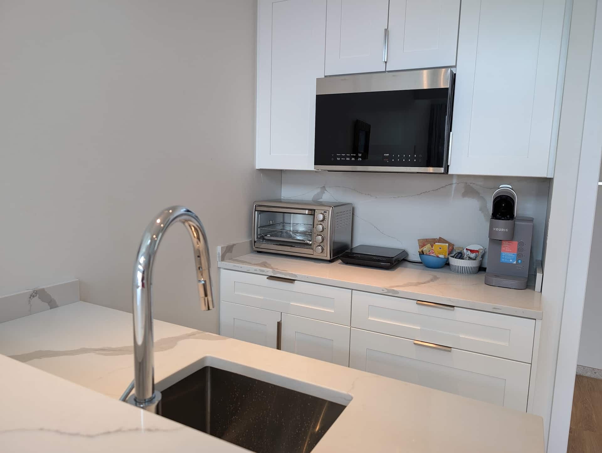 Modern white kitchenette with toaster oven and coffee maker